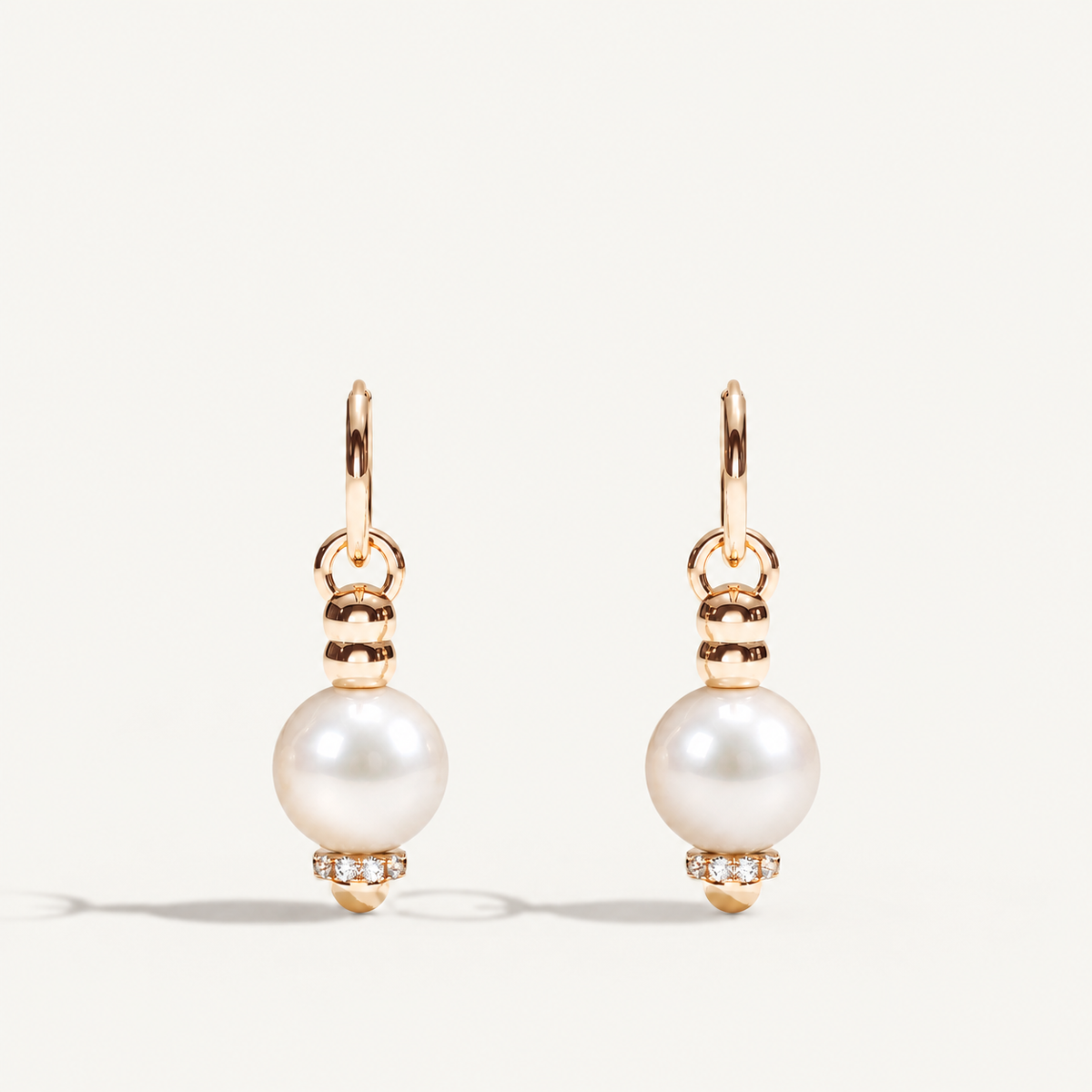Barbelle Creole Ear Pendants – South Sea pearls, rose gold and diamonds on warm off-white background. Product visualization.