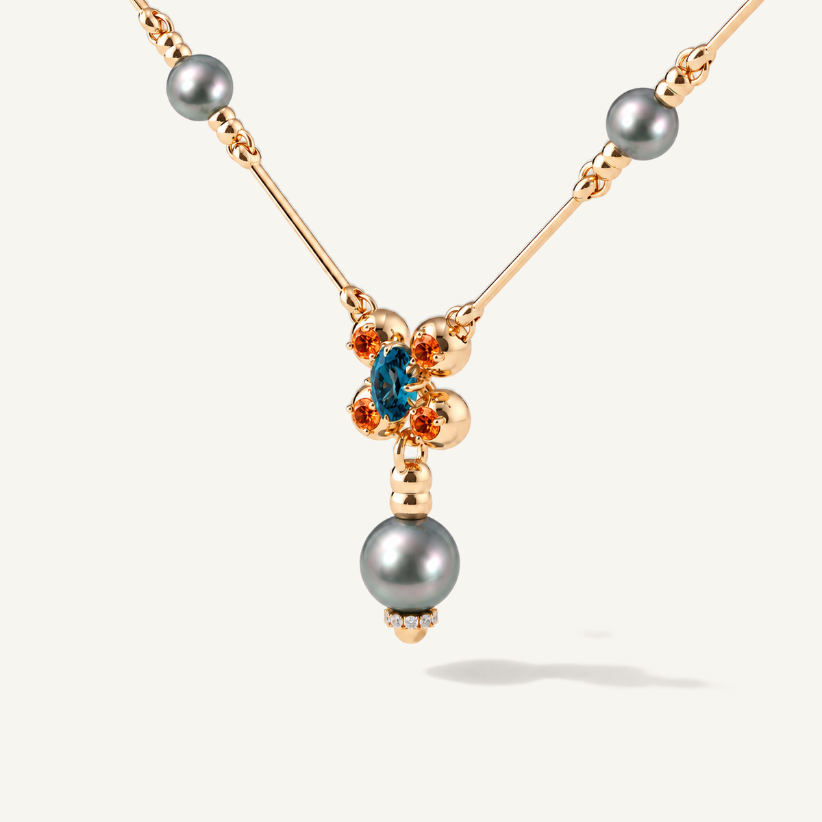 Barbelle necklace with grey Tahitian pearls, London blue topaz and mandarin garnets — angle two